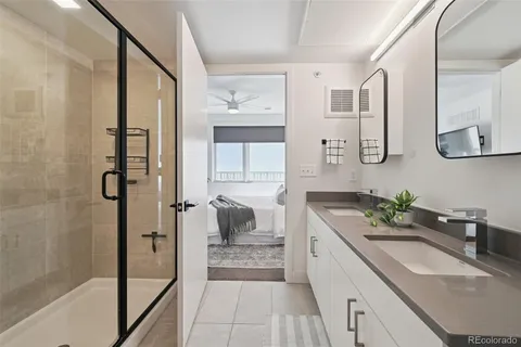 a spacious bathroom with a granite countertop sink mirror and shower