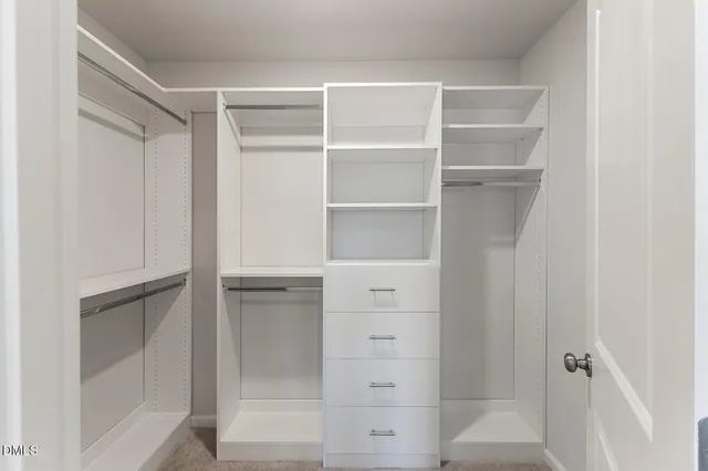 a view of walk in closet with empty racks