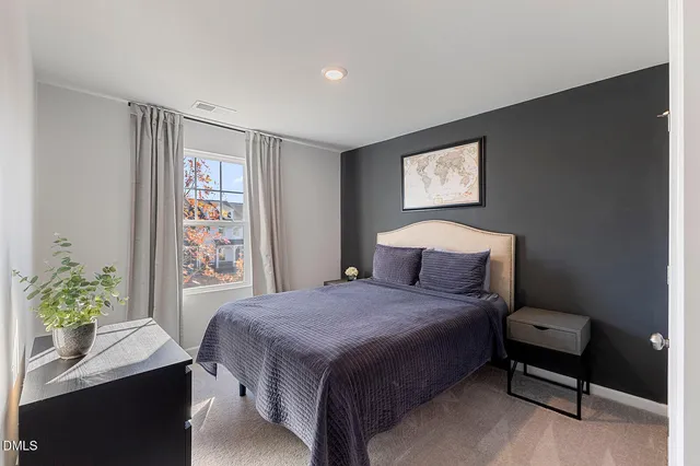 a bedroom with a bed table chair and a window