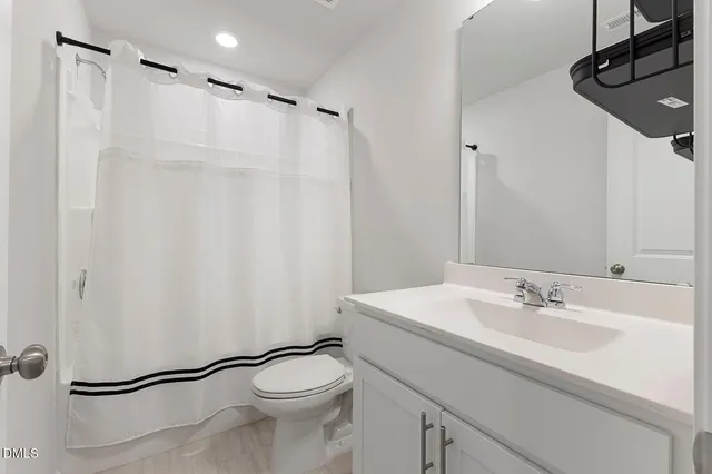 a bathroom with a sink a toilet a shower and a mirror