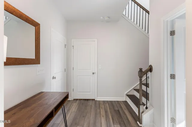 a view of a hallway with wooden floor and staircase