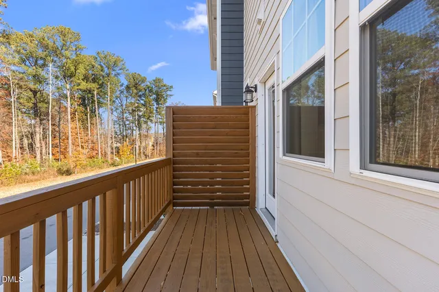 a view of a balcony with wooden floor and fence