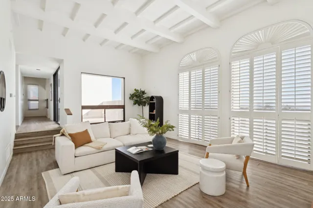 a living room with furniture a wooden floor and a large window