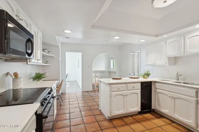 a kitchen with a sink a refrigerator and cabinets