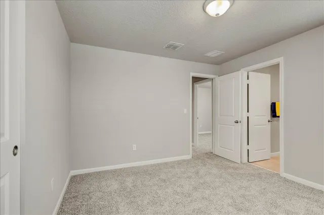 an empty room with windows and ceiling fan