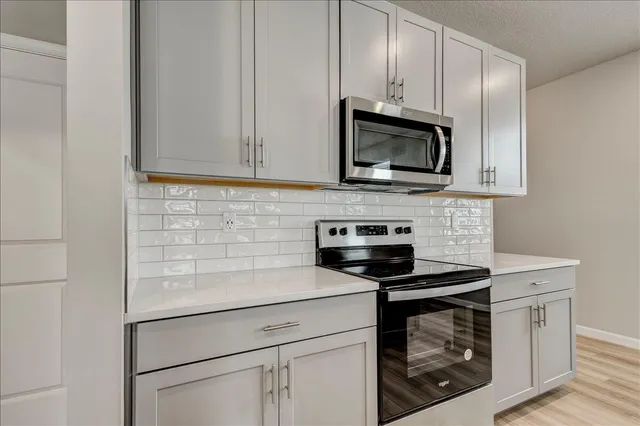 a kitchen with stainless steel appliances a stove microwave and sink