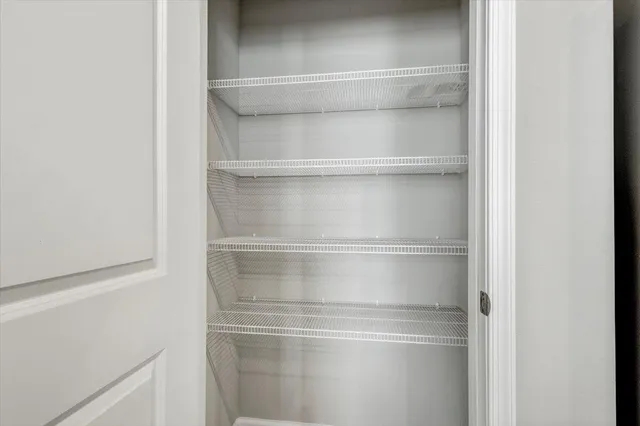 a view of an empty room with a chandelier fan and wooden floor