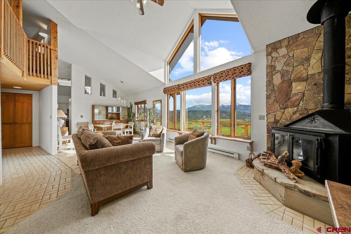 12979 County Road 1 Ridgway, CO 81432 - Photo 7 of 35 a living room with furniture a fireplace and large windows