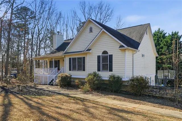 a front view of house with yard and trees around