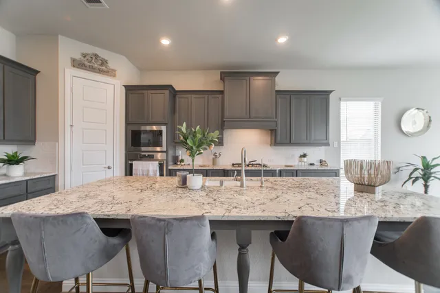 a kitchen with granite countertop kitchen island white cabinets and stainless steel appliances