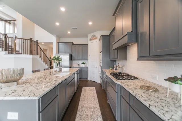 a kitchen with stainless steel appliances granite countertop a stove a sink and a refrigerator