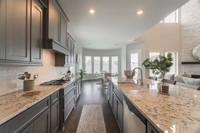 a kitchen with sink a stove and cabinets