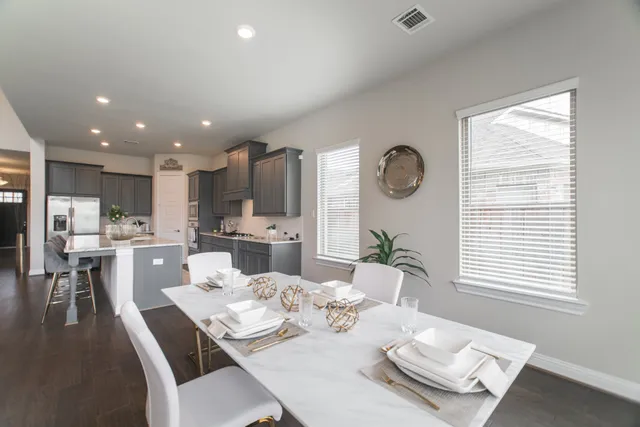 a dining room with wooden floor and a large window