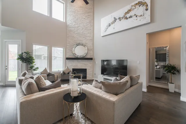 a living room with furniture a flat screen tv and a fireplace