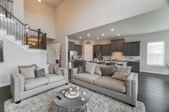 a living room with furniture kitchen and a wooden floor