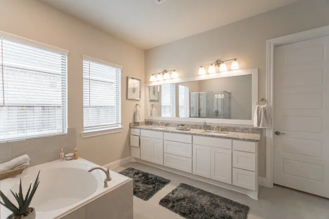 a bathroom with a tub sink and mirror