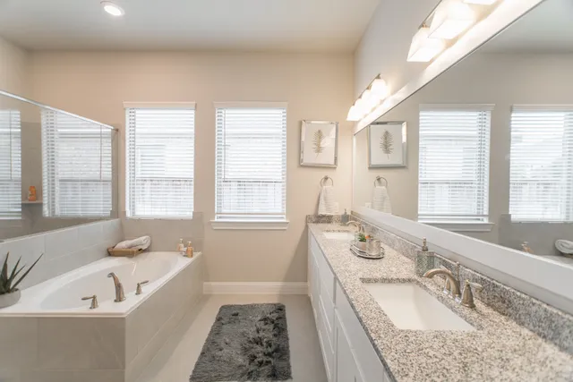 a bathroom with a granite countertop tub sink and mirror