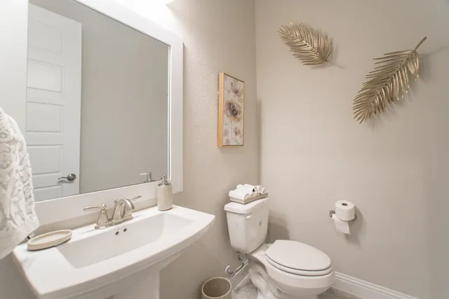 a bathroom with a sink mirror and a toilet