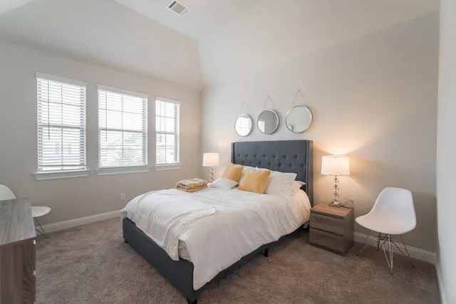 a bedroom with a bed and a lamp next to a window