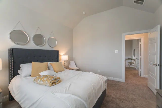 a bedroom with a bed and painting on the wall