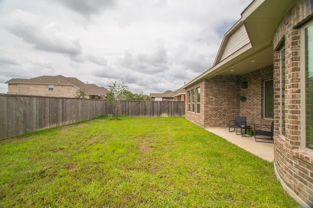 a view of a backyard with table and chairs and wooden fence