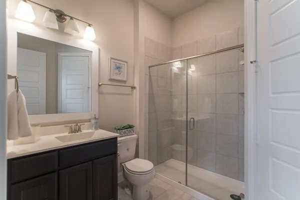 a bathroom with a shower sink vanity and toilet