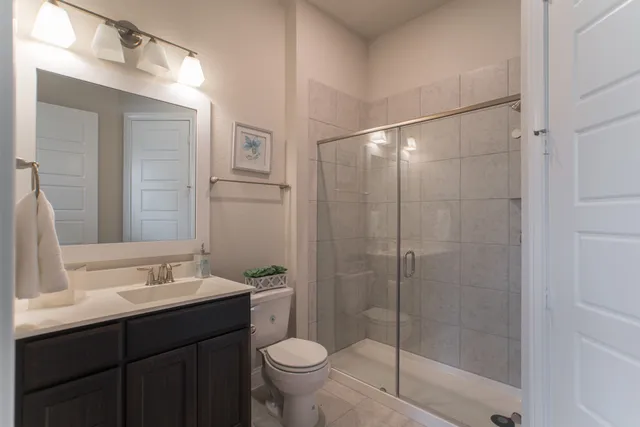 a bathroom with a shower sink vanity and toilet