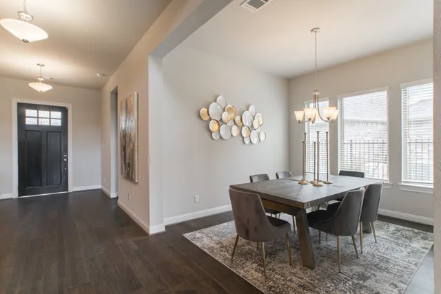 a dining room with furniture a chandelier and wooden floor