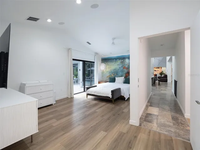 a view of a bedroom with wooden floor and furniture