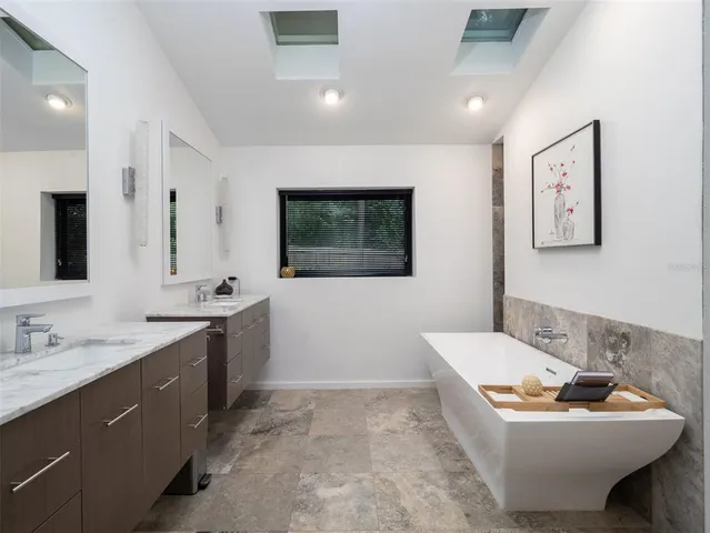 a bathroom with a sink mirror and tub