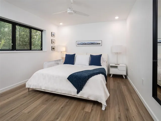 a bedroom with a bed and wooden floor