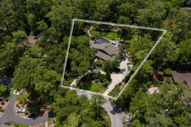 an aerial view of house with swimming pool and garden