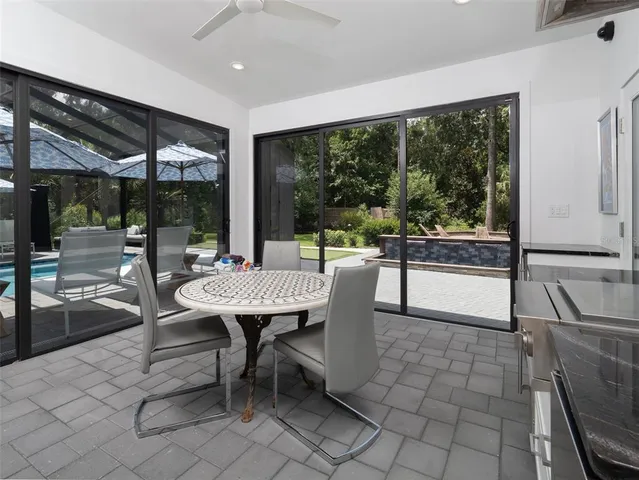 a dining room with furniture and large windows