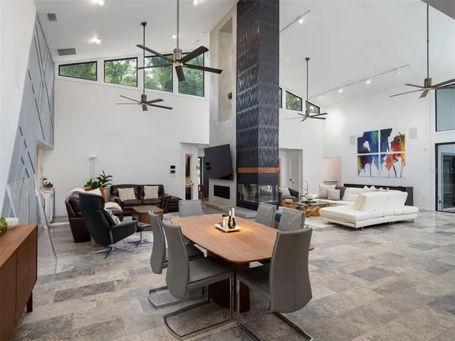 a living room with furniture kitchen view and a chandelier