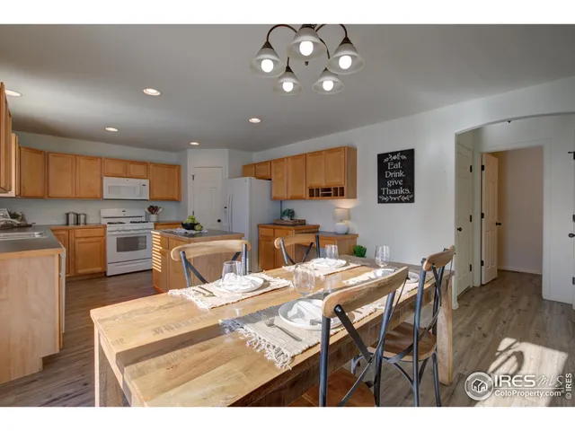 a open kitchen with stainless steel appliances granite countertop a sink a stove a dining table and chairs