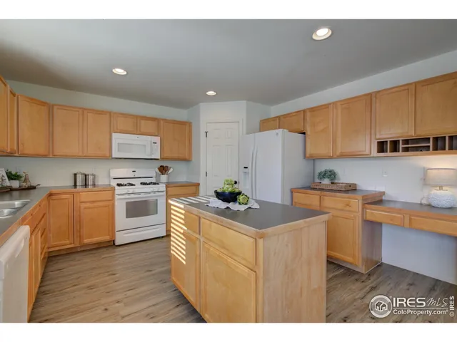 a kitchen with granite countertop a refrigerator stove top oven a sink and dishwasher