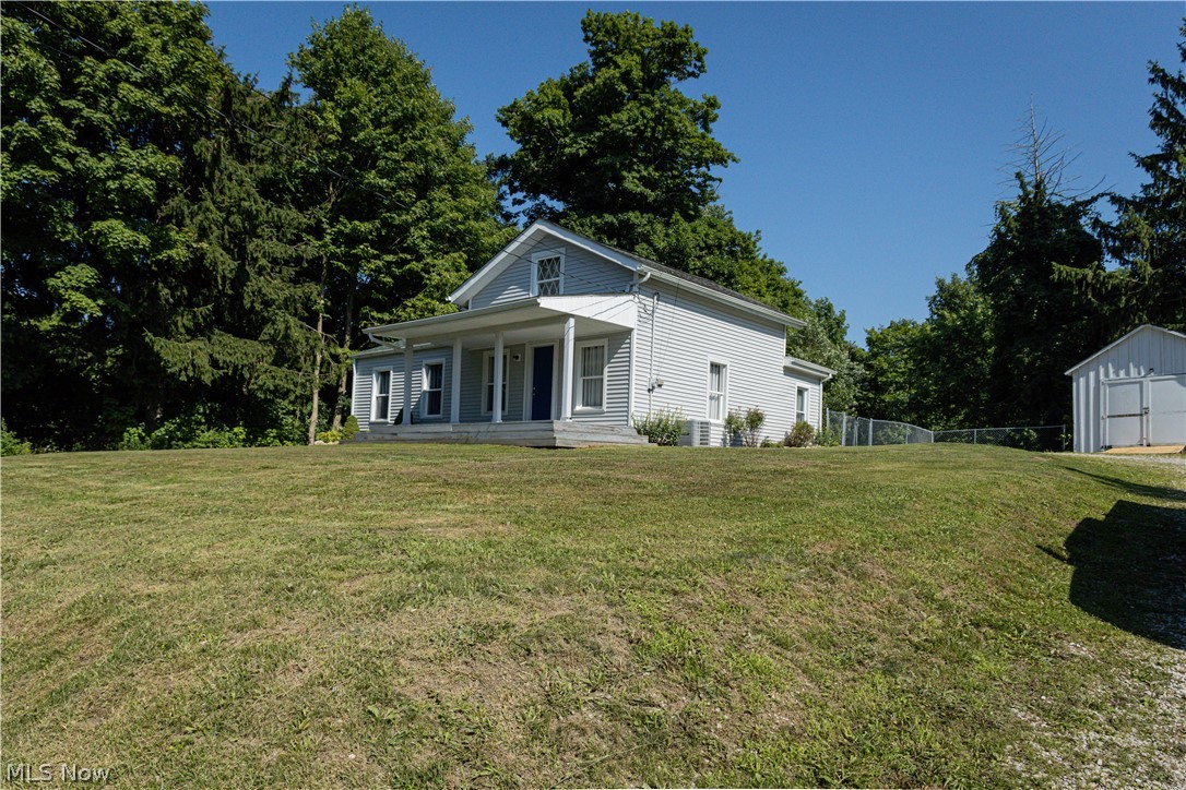 180 South Ridge Road West Geneva, OH 44041 - Photo 40 of 40 Rear view of house featuring a porch and a lawn