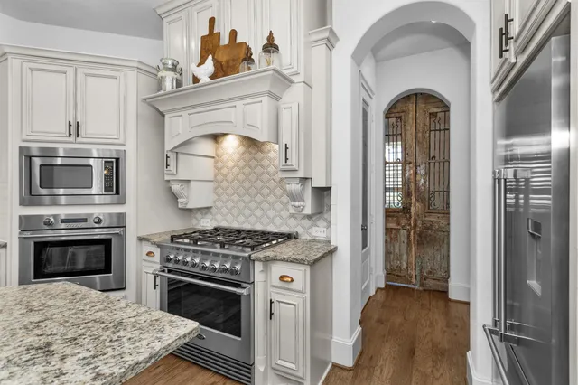 a kitchen with stainless steel appliances granite countertop a stove and a refrigerator