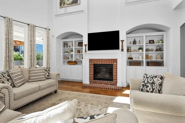 a living room with furniture a flat screen tv and a fireplace