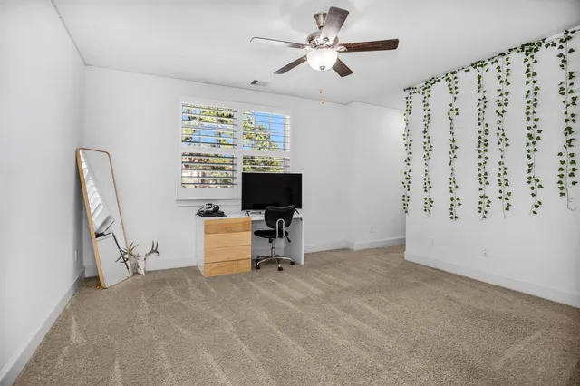 a view of a livingroom with workspace and a window