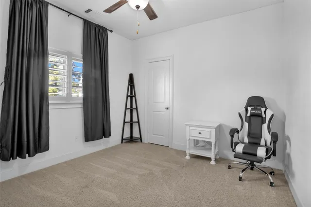 a view of a workspace with furniture and a window