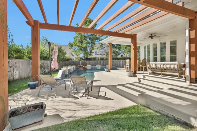 a view of a patio with table and chairs potted plants with wooden floor and fence