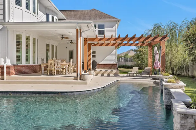 a view of a house with pool and sitting area