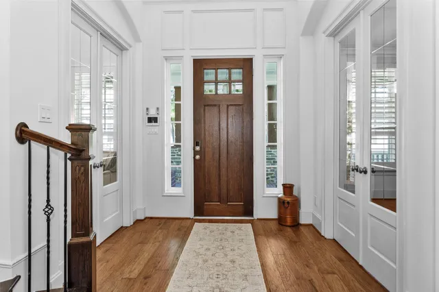 a view of a hallway with wooden floor and windows