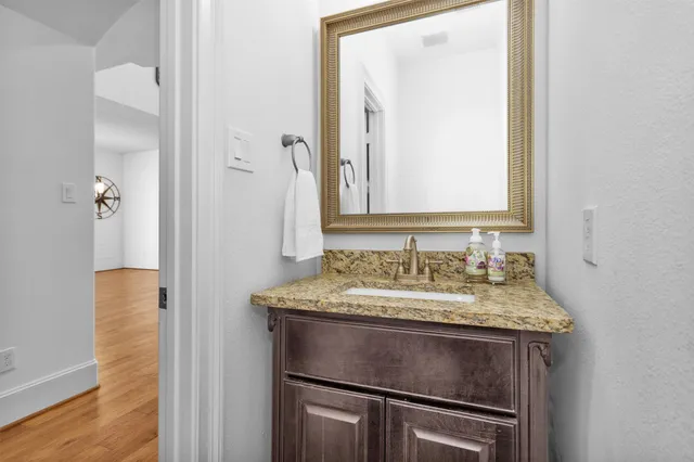 a bathroom with a granite countertop sink and a mirror