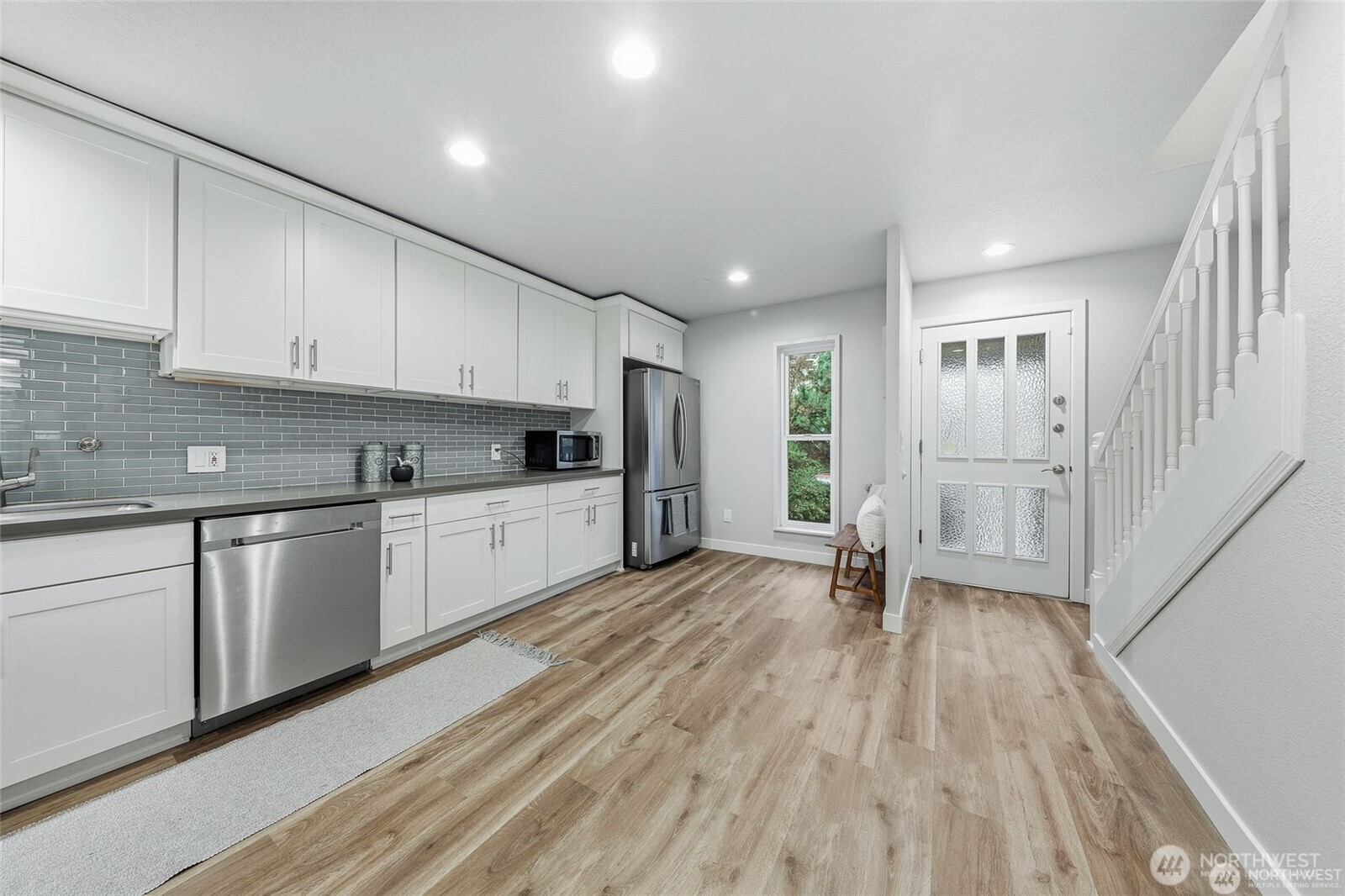 1940 North Northgate Way Seattle, WA 98133 - Photo 11 of 22 a large white kitchen with stainless steel appliances granite countertop a refrigerator oven a sink dishwasher and white cabinets with wooden floor