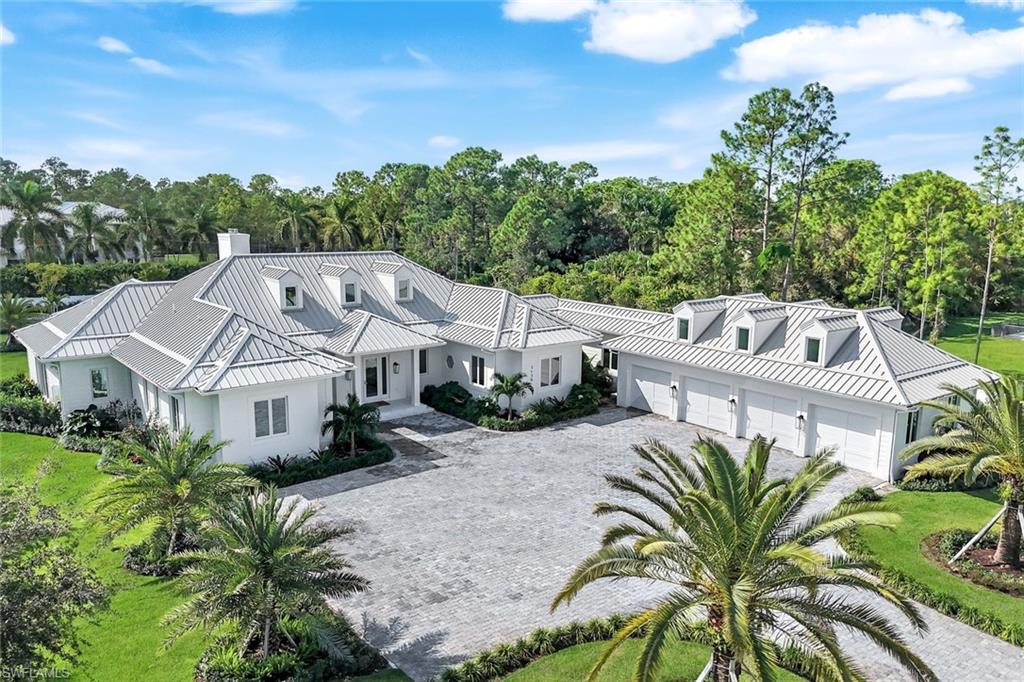 View of front of house featuring a standing seam roof, a metal roof, and decorative driveway