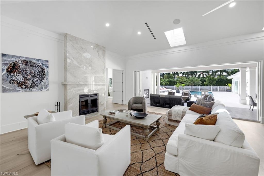 3136 Ravenna Avenue Naples, FL 34120 - Photo 17 of 50 Living area featuring a fireplace, wood finished floors, recessed lighting, a skylight, and crown molding