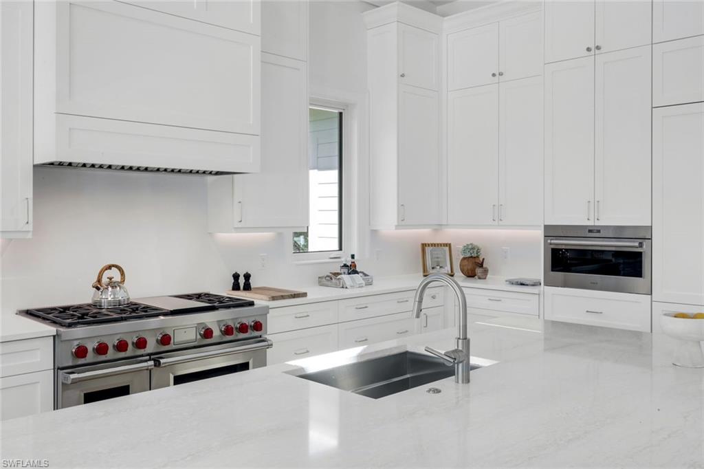 3136 Ravenna Avenue Naples, FL 34120 - Photo 22 of 50 Kitchen featuring stainless steel appliances, white cabinetry, and light stone countertops