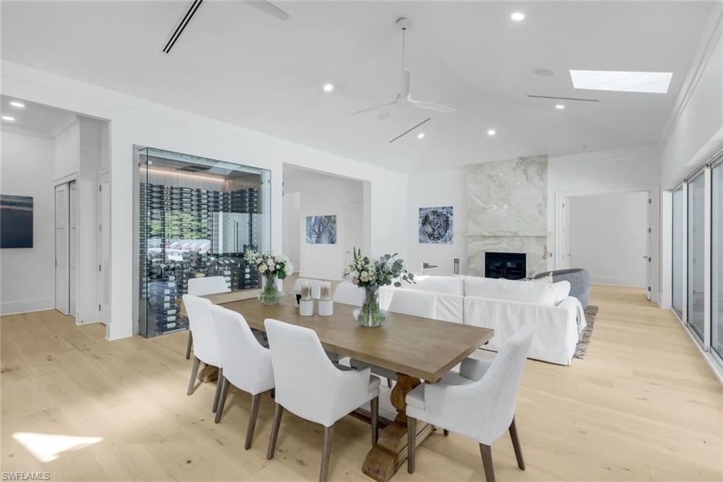 3136 Ravenna Avenue Naples, FL 34120 - Photo 24 of 50 Dining room with a fireplace, light wood-style floors, recessed lighting, a skylight, and a ceiling fan